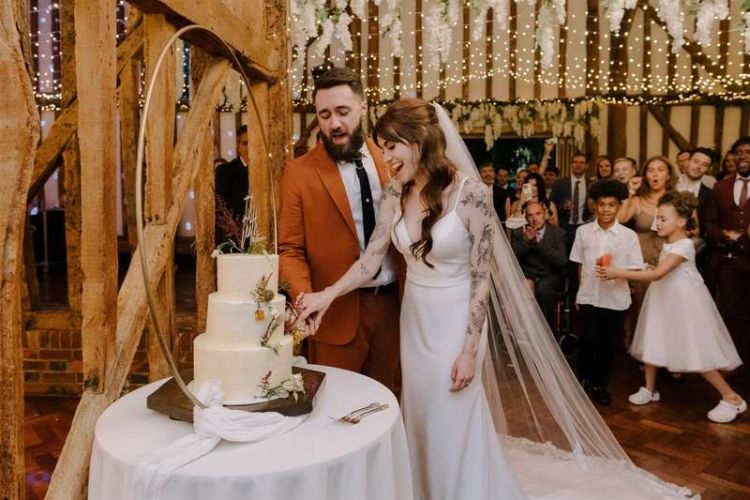 Couple cutting the cake at Crondon park barn wedding venue